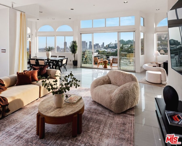 living room featuring a towering ceiling and light tile patterned floors