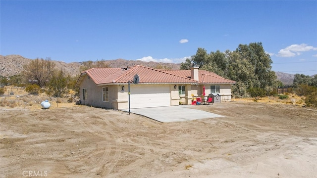 view of property exterior with a mountain view and a garage