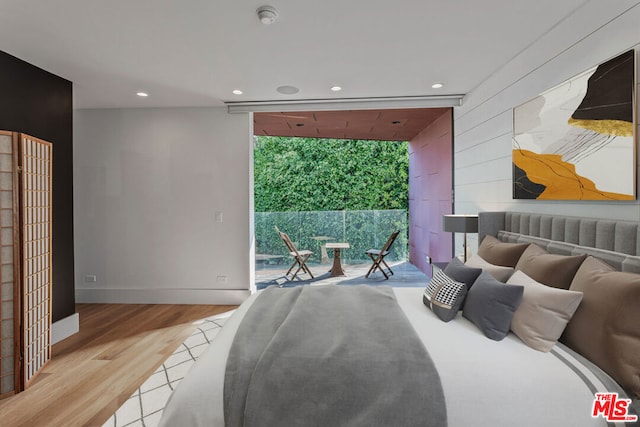 bedroom featuring access to exterior and light wood-type flooring