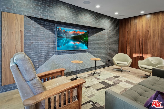 cinema room with wood walls and light wood-type flooring