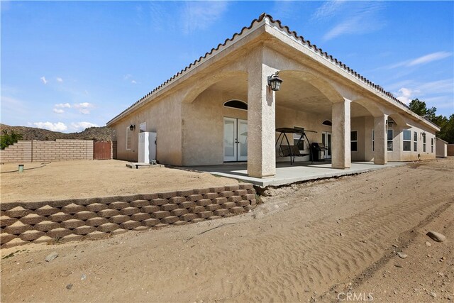 rear view of property featuring french doors and a patio area