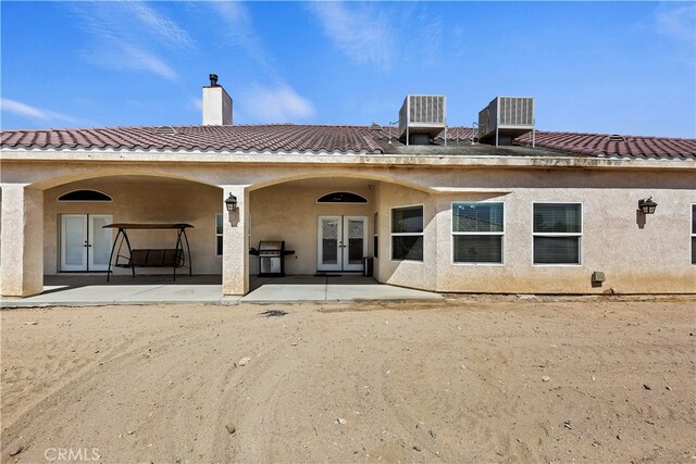 back of house featuring central air condition unit, french doors, and a patio area