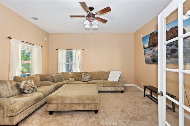 carpeted living room with ceiling fan