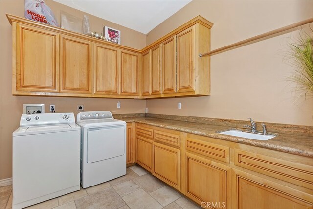 laundry room with washer and clothes dryer, cabinets, and sink