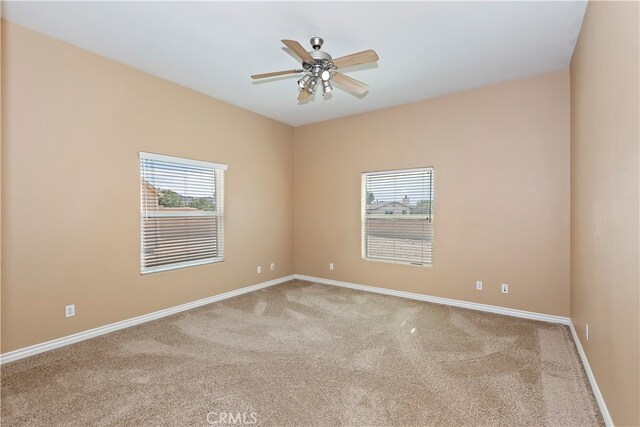 carpeted spare room featuring ceiling fan