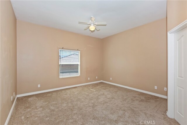 spare room with ceiling fan and light colored carpet