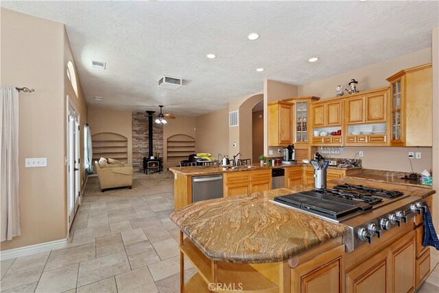 kitchen with ceiling fan, stainless steel appliances, kitchen peninsula, and a kitchen island