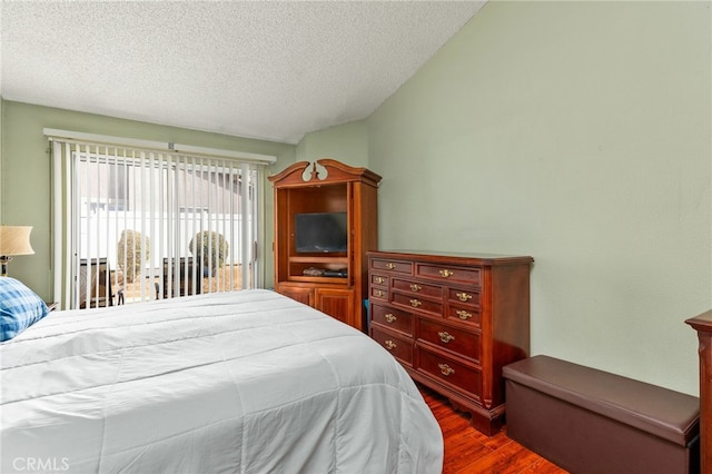 bedroom featuring dark wood-style floors and a textured ceiling