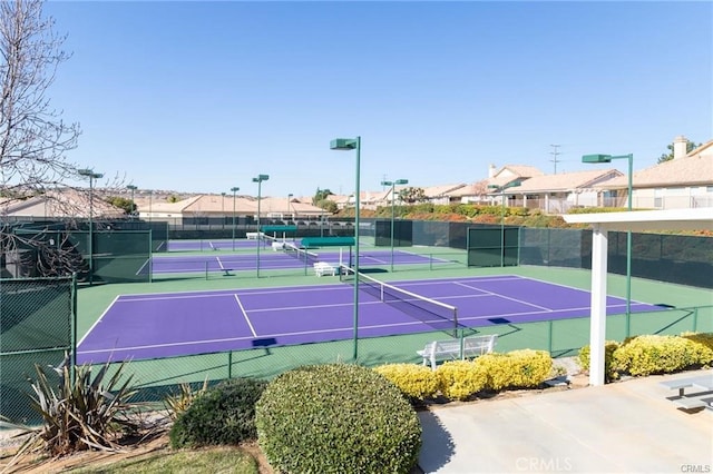 view of sport court with a residential view and fence