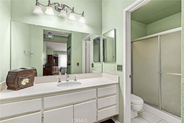 ensuite bathroom featuring toilet, ensuite bathroom, tile patterned flooring, vanity, and a shower stall