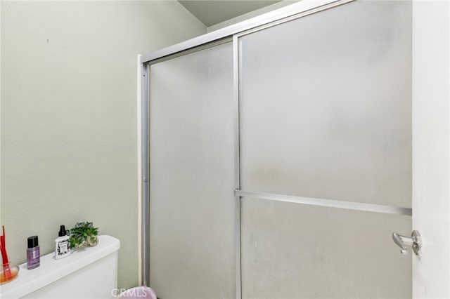 bathroom with toilet and an enclosed shower