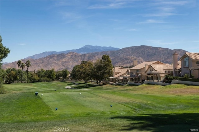 view of community with a residential view, view of golf course, a mountain view, and a lawn