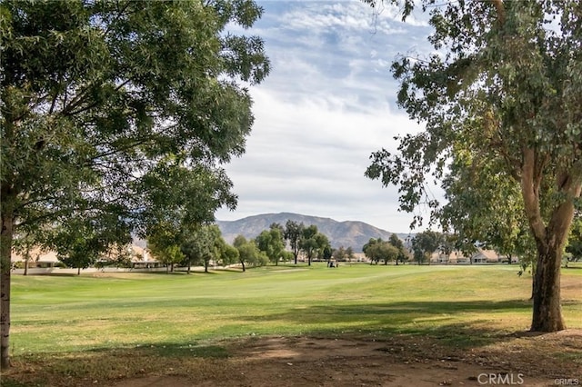 surrounding community with a yard, golf course view, and a mountain view