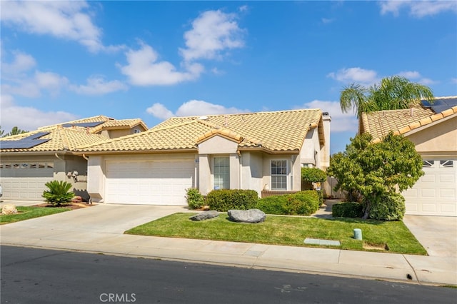 mediterranean / spanish-style house with a front lawn and a garage