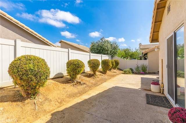 view of yard with a fenced backyard, visible vents, and a patio