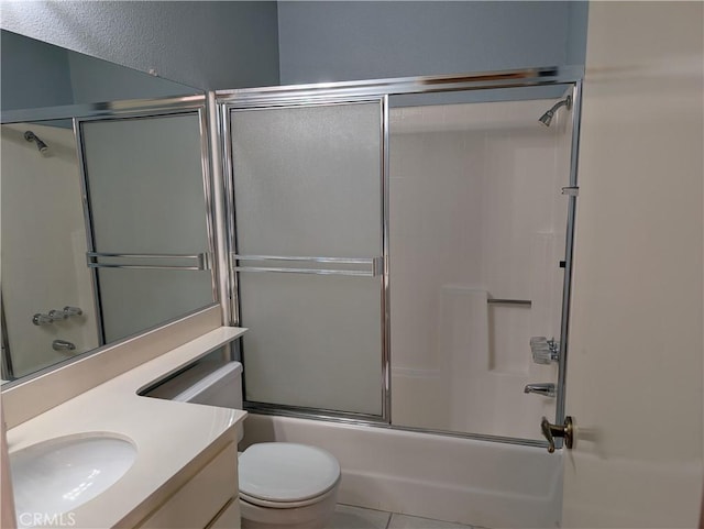 full bath featuring enclosed tub / shower combo, tile patterned flooring, vanity, and toilet