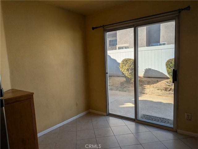 doorway featuring light tile patterned floors and baseboards