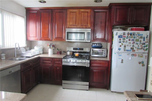 kitchen featuring appliances with stainless steel finishes, light tile patterned floors, and sink