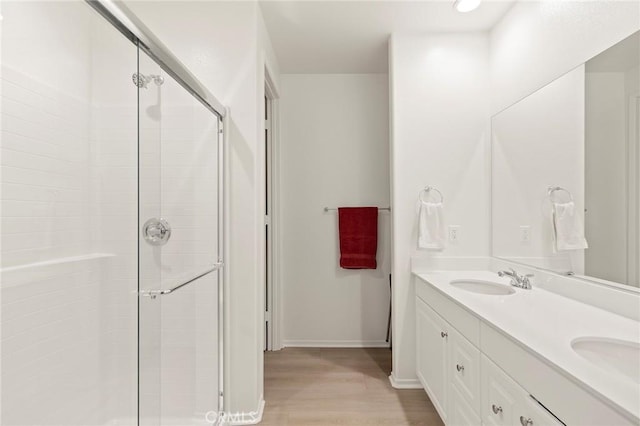 bathroom featuring vanity, an enclosed shower, and wood-type flooring