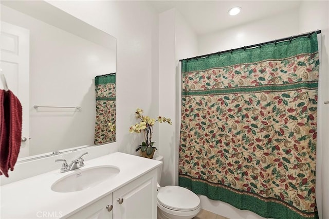 bathroom with walk in shower, vanity, and toilet