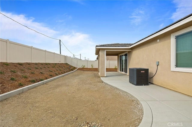 view of yard with central AC unit and a patio area