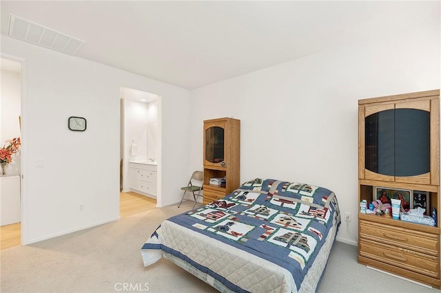 carpeted bedroom featuring ensuite bath