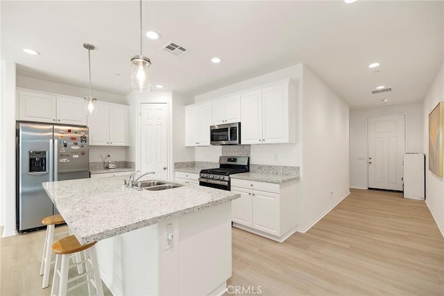 kitchen featuring white cabinets, decorative light fixtures, stainless steel appliances, and sink