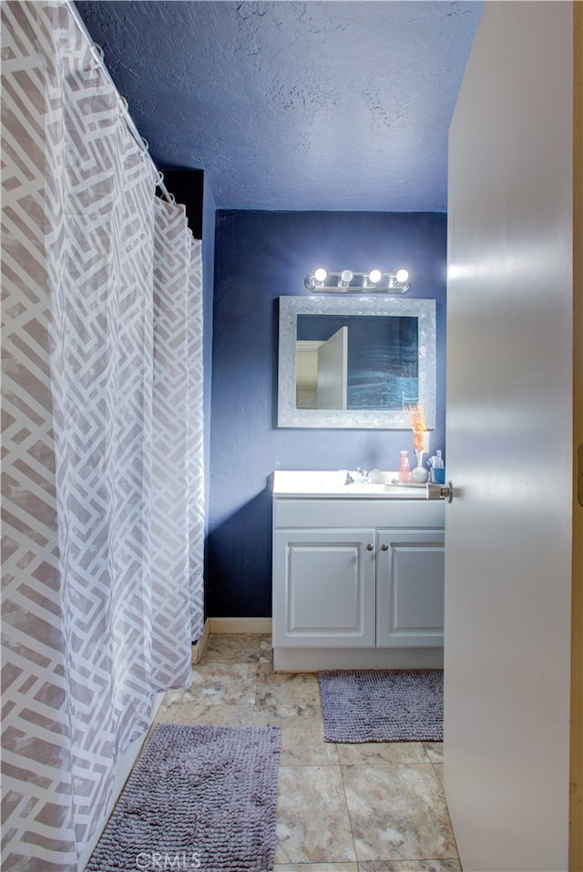 bathroom featuring a textured ceiling, vanity, a shower with shower curtain, and tile patterned floors