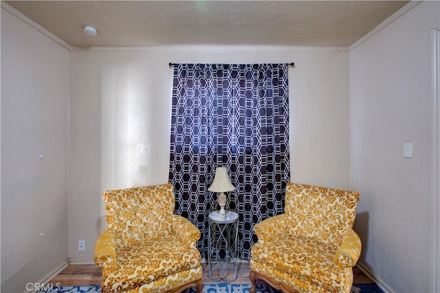 sitting room with crown molding and hardwood / wood-style flooring