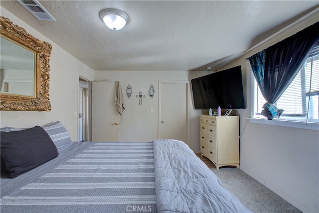 bedroom featuring a textured ceiling and carpet flooring