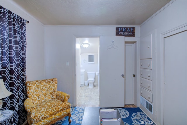 living area with ornamental molding and a textured ceiling