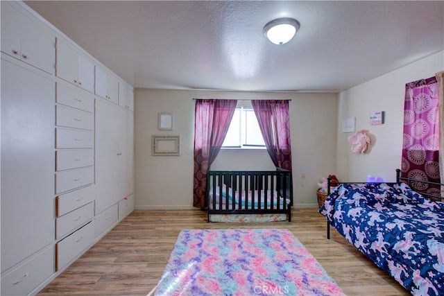 bedroom with light wood-type flooring and a closet