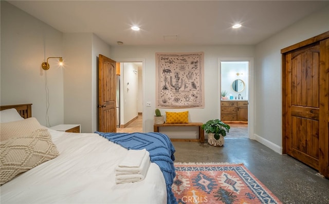 bedroom featuring connected bathroom and concrete floors