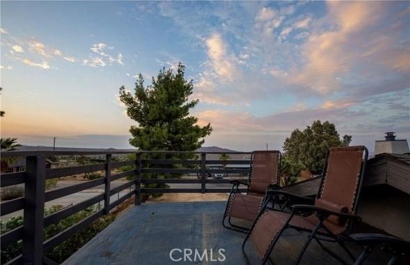 patio terrace at dusk featuring a balcony