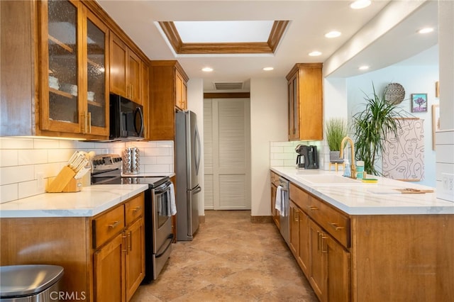 kitchen featuring sink, appliances with stainless steel finishes, a raised ceiling, and tasteful backsplash