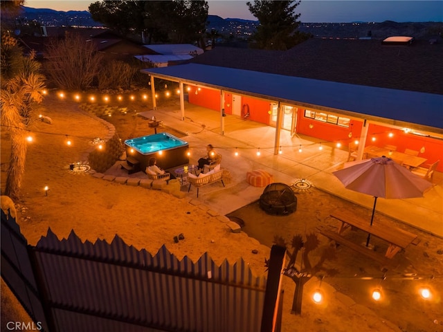 pool at dusk featuring a patio and a fire pit