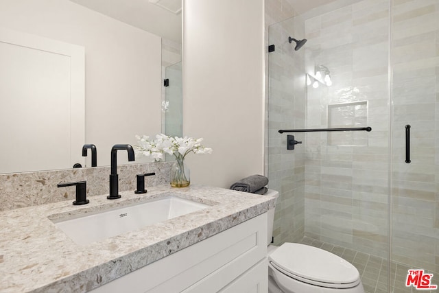 bathroom featuring vanity, toilet, and a shower with door