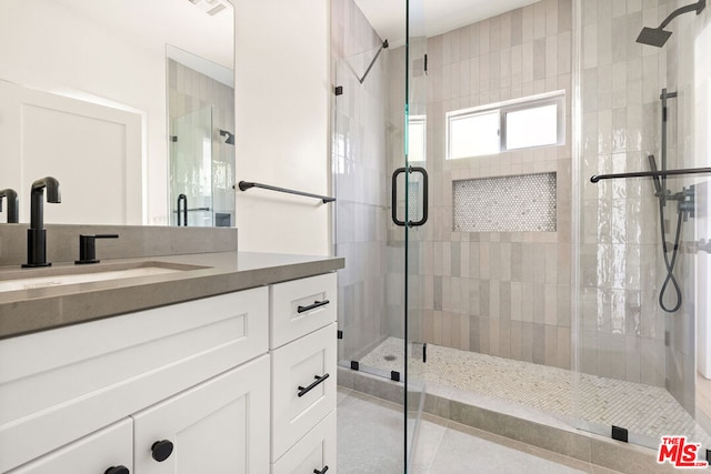 bathroom with tile patterned flooring, vanity, and an enclosed shower