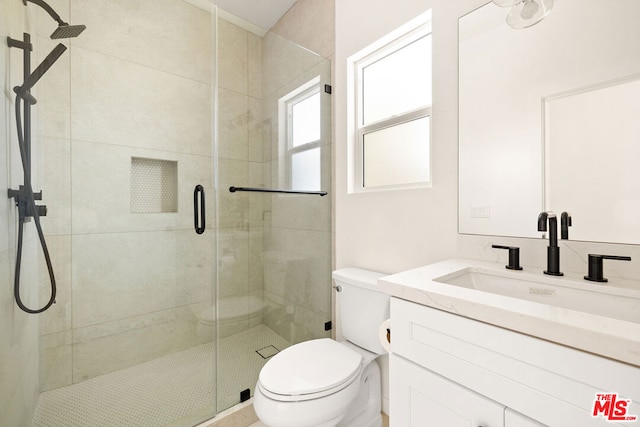 bathroom with vanity, a shower with shower door, and toilet