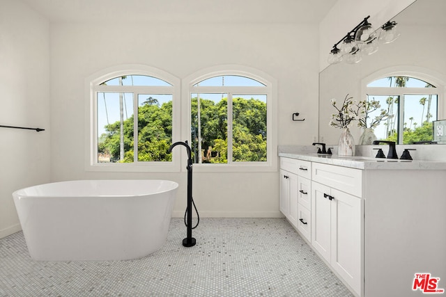 bathroom with vanity, tile patterned flooring, and a bath