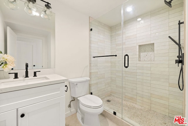 bathroom featuring walk in shower, vanity, tile patterned flooring, and toilet