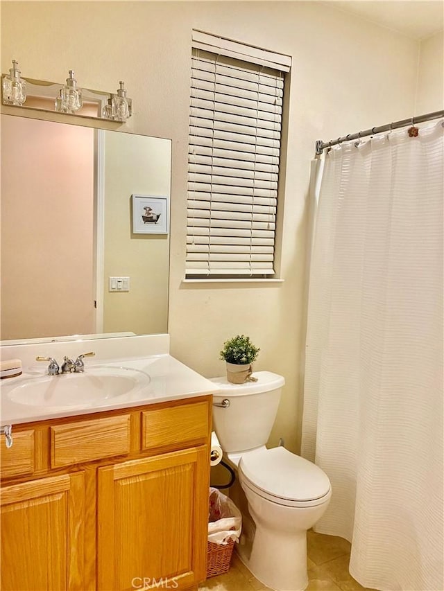 bathroom with tile patterned flooring, vanity, and toilet