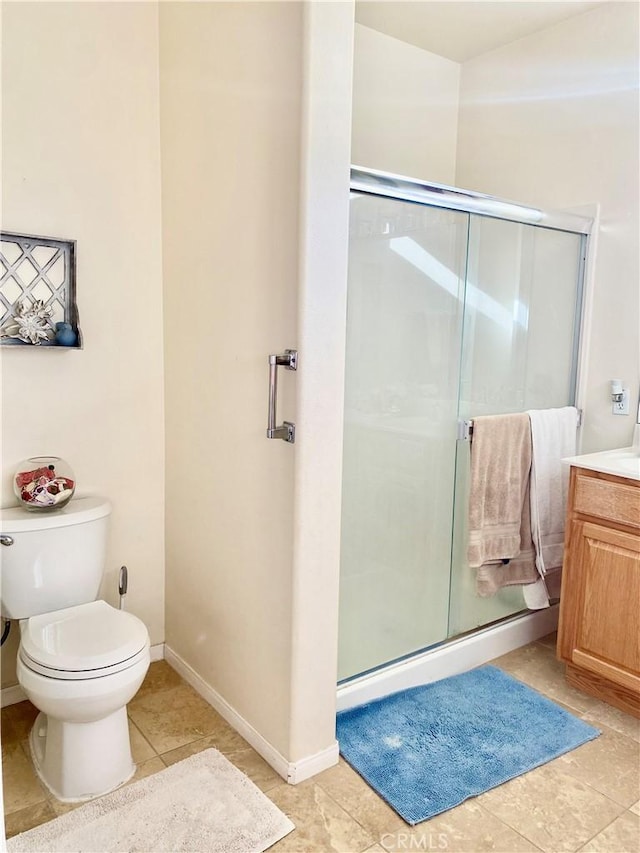 bathroom featuring tile patterned flooring, vanity, toilet, and a shower with shower door