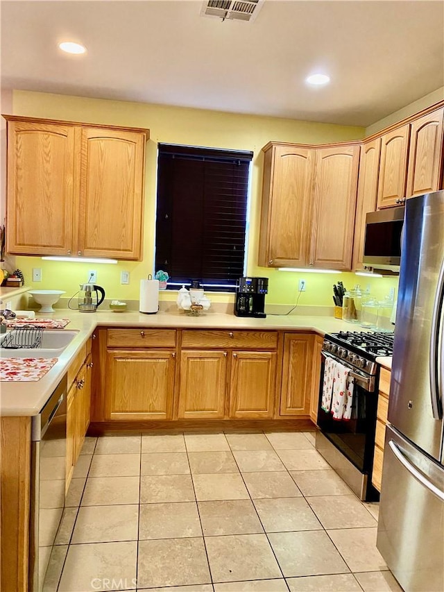 kitchen with light tile patterned floors, stainless steel appliances, and sink