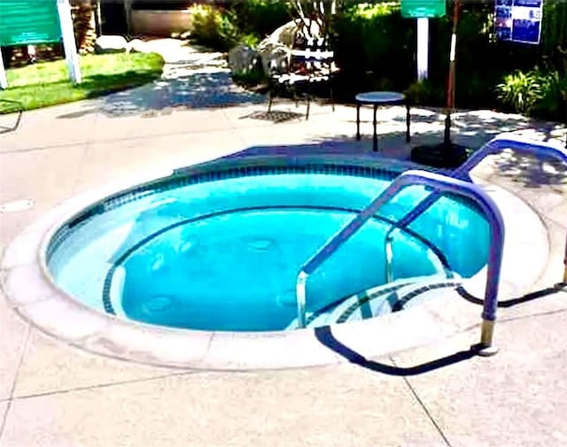 view of swimming pool featuring a community hot tub