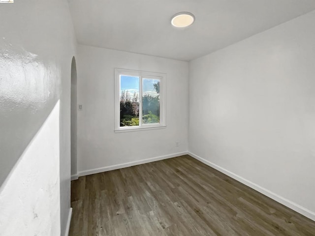 empty room with dark hardwood / wood-style flooring