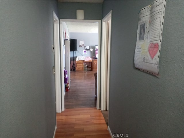 hallway with hardwood / wood-style flooring