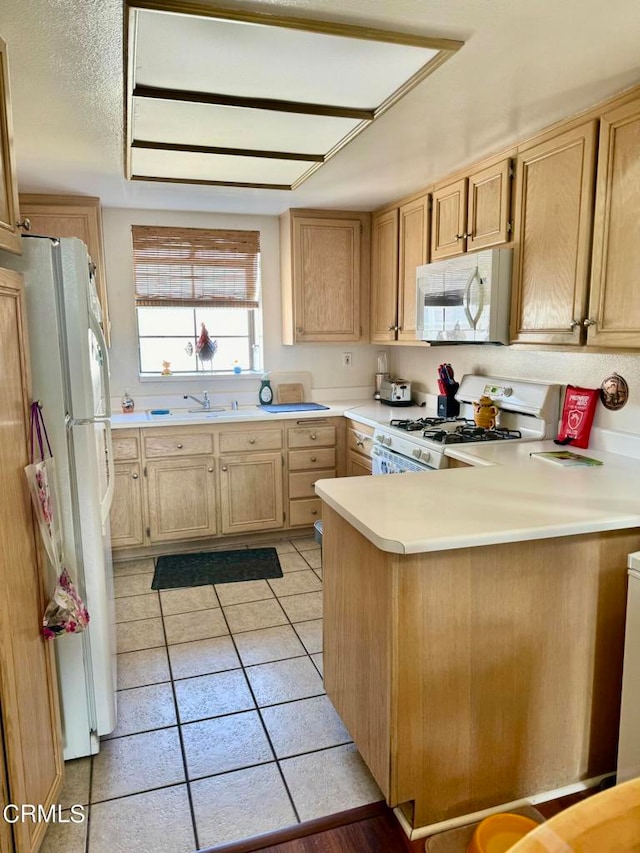 kitchen featuring light brown cabinets, light tile patterned flooring, kitchen peninsula, and white appliances