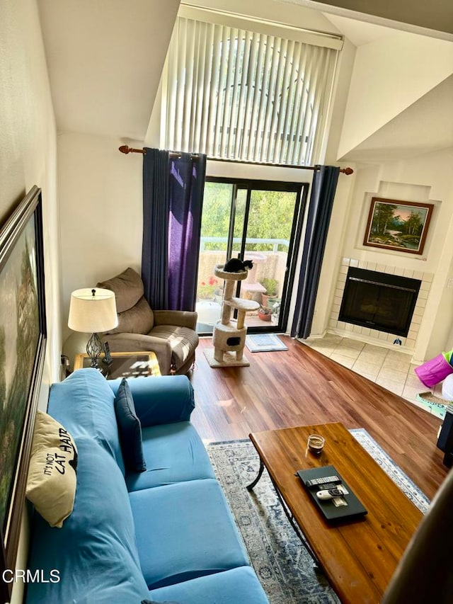 living room with a tile fireplace and hardwood / wood-style flooring