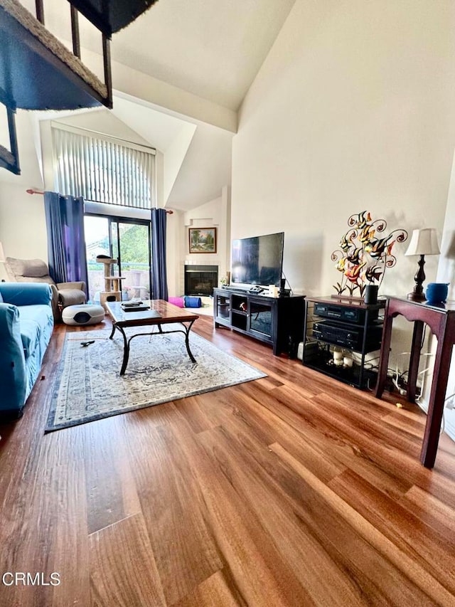 living room with high vaulted ceiling and hardwood / wood-style flooring